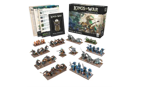 A display of the "Claws in the Sand" 2-Player Starter Set for Kings of War features a variety of miniatures and game components. The set includes two distinct armies: one with orange and brown figures, and another with blue and grey figures, arranged on bases. In the background, the box for the starter set is visible, showcasing artwork of warriors in battle, along with rulebooks and army lists laid out beside it.