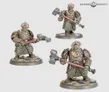 Three miniature figures of armored Khazalite duardin warriors, each holding a weapon: one with a hammer, one with a gun, and one with a pickaxe. Detailed metal armor with intricate patterns, standing on round bases with textured terrain.