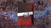 The image features the cover of the "Hot War" RPG rulebook, prominently displayed against a background of a map depicting a devastated London. The cover is predominantly red with a textured finish, featuring bold white text that reads "HOT WAR" along with the subtitle "Second Edition." The design conveys a sense of urgency and conflict, reflecting the game's themes of survival in a post-apocalyptic setting. The map in the background shows a river winding through a cityscape, hinting at the urban environment where the game takes place.