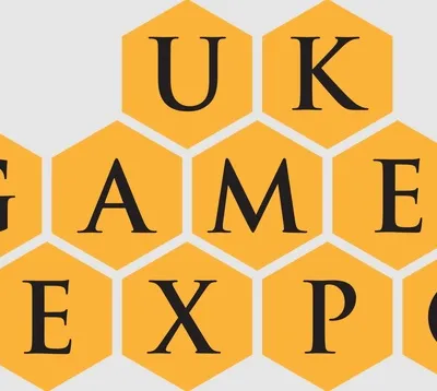 The design features the text "UK GAMES EXPO" arranged in a honeycomb pattern, with each letter placed inside a yellow hexagon. The font is bold and black, creating a strong contrast against the yellow background. The overall layout emphasizes the event's branding in a visually engaging manner.