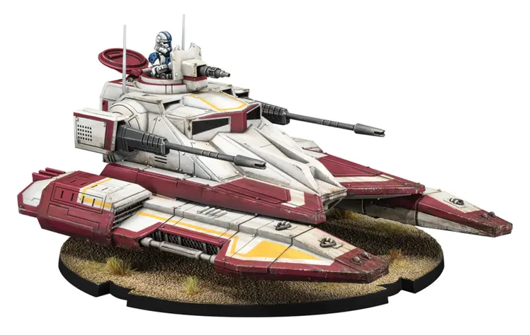 A detailed miniature of the TX-130 Saber-class fighter tank, featuring a sleek design with a predominantly white and red color scheme. The tank is equipped with a beam cannon and twin laser cannons, showcasing its heavy armament. A clone trooper pilot is seated in the turret, and the base is textured to resemble a sandy terrain with small patches of grass.