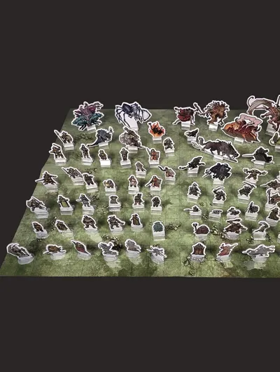 Cardboard standees of fantasy characters and creatures on a green grid map.