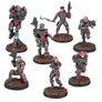 A collection of seven miniatures from the Nomads faction in the Infinity miniatures game, showcasing a cyberpunk aesthetic. The figures include three Gatta Alguaciles armed with Submachine Guns, a Corregidor Bandit, a Bearcat Paramedic, a Territorial, and a Vigilante, each with distinct poses and weaponry. The miniatures are painted in vibrant colors, primarily featuring red and teal accents, set against textured bases that enhance their dynamic appearance.