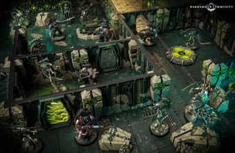 A detailed tabletop gaming scene features a futuristic battlefield with intricate terrain and structures. In the foreground, two armored figures wielding weapons stand ready, while several robotic Necron warriors are positioned strategically among the ruins. The environment is characterized by dark green and metallic colors, with glowing elements and a circular control panel in the center, enhancing the sci-fi atmosphere.