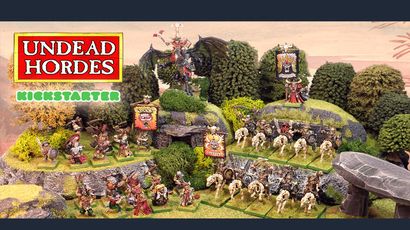 The scene features a vibrant tabletop display showcasing the "Undead Hordes" miniatures from Red Bard Games' Kickstarter campaign. In the foreground, a variety of skeletons and zombies are arranged on grassy terrain, with some holding banners and others in dynamic poses. A prominent liche king rides a zombie dragon atop a rocky outcrop, while additional figures, including a necromancer and various undead warriors, populate the scene, surrounded by lush greenery and stone formations. The overall composition exudes a classic fantasy aesthetic, emphasizing the theme of an undead army ready for battle.