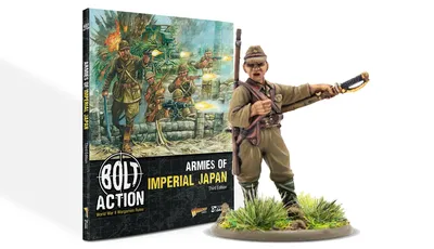 A book titled "Armies of Imperial Japan" from Warlord Games is prominently displayed, featuring a colorful cover illustration depicting Japanese soldiers in action, with a backdrop of explosions and military equipment. The book is positioned upright, showcasing its spine and cover, while a detailed 28mm miniature of a Japanese soldier is placed in the foreground, emphasizing the theme of the game. The text on the cover highlights the book's focus on World War II wargaming rules for the Imperial Japanese Army.
