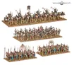 Miniature models of three groups of skeleton warriors and archers in battle formation on sandy terrain. Top row: mounted skeletons with spears and banners. Middle row: infantry with shields, spears, and a central figure holding a large shield with a red symbol.