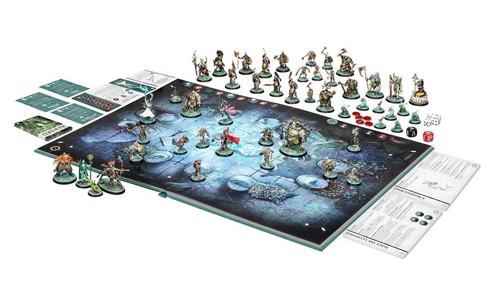 A tabletop gaming scene features a lay-flat game board with a dark, textured surface, surrounded by numerous miniatures representing heroes and villains. In the center, several characters are positioned, including a large, imposing figure and various smaller ones, while additional miniatures are arranged along the edges. Accompanying the board are tokens, dice, and rule cards, indicating a setup for a strategic game session.