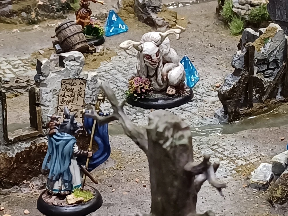 A whimsical scene features a fantastical creature resembling a goat or sheep with large horns, sitting on a rocky terrain adorned with greenery and small flowers. Nearby, a character in a blue cloak holds a sign that reads,