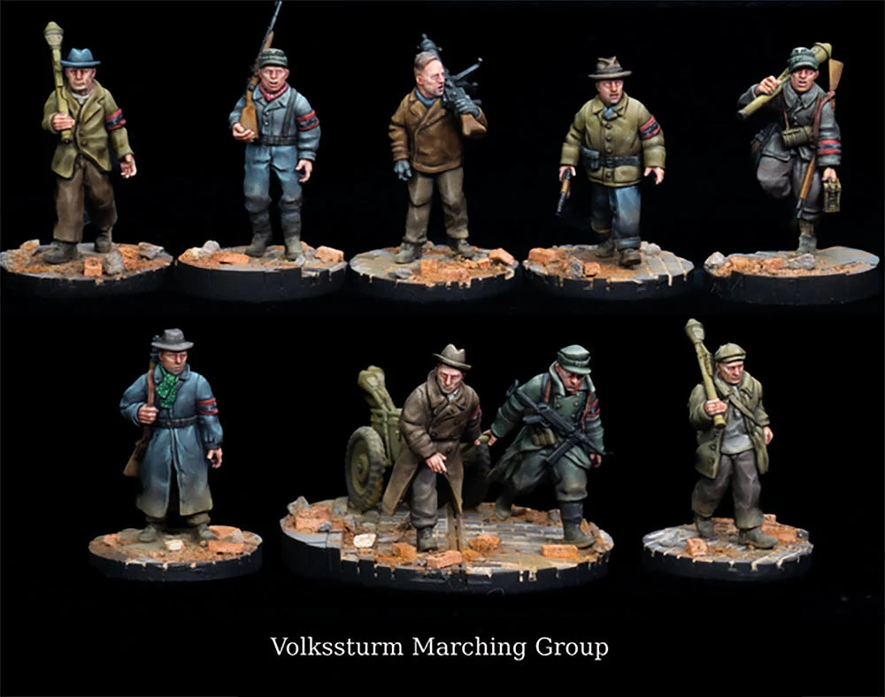 A collection of detailed miniatures representing a Volksturm marching group, showcasing various figures in WWII-era attire. The miniatures are painted in muted colors, with some wearing overcoats and others in military uniforms, each holding weapons or equipment. They stand on scenic bases featuring rubble and debris, enhancing the historical context of the scene.