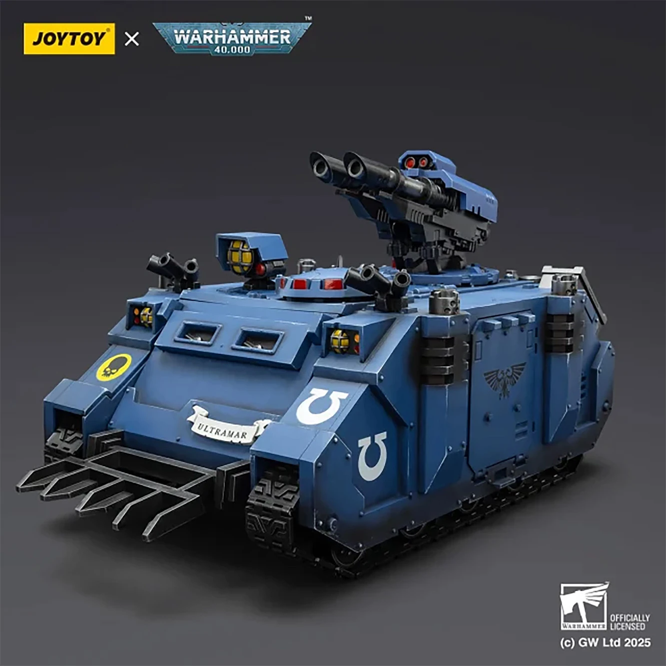 A detailed model of the JoyToy Ultramarines Razorback, a military vehicle from the Warhammer 40,000 universe, is prominently displayed. The vehicle is painted in a striking blue color, featuring the Ultramarines insignia and various tactical details, including twin lascannons mounted on top. The front showcases a rugged design with a grill and additional lights, emphasizing its battle-ready appearance.