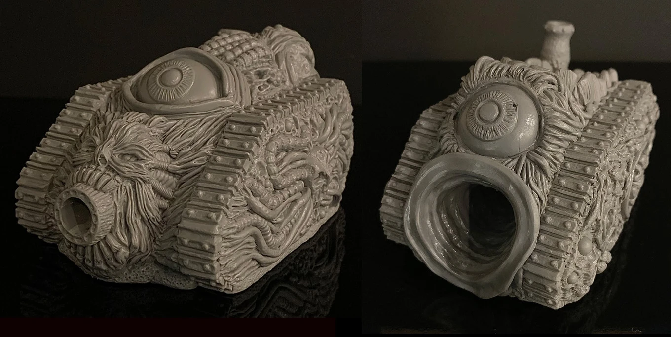 A grotesque tank model designed for a Chaos army, featuring a textured surface adorned with various orifices, boils, and an eye-like detail on the front. The tank has a large, gaping mouth-like opening, emphasizing its disturbing aesthetic. The model is presented in a gray, unpainted finish, showcasing intricate sculpting details that highlight its bizarre and unsettling design.
