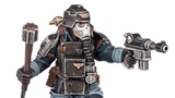 A detailed miniature figure of a Death Korps of Krieg Combat Engineer, wearing a dark uniform and a distinctive helmet with a skull motif. The figure is equipped with various tools and weapons, including a pistol in one hand and a device in the other. The overall color scheme features dark tones with metallic accents, emphasizing the character's militaristic design.