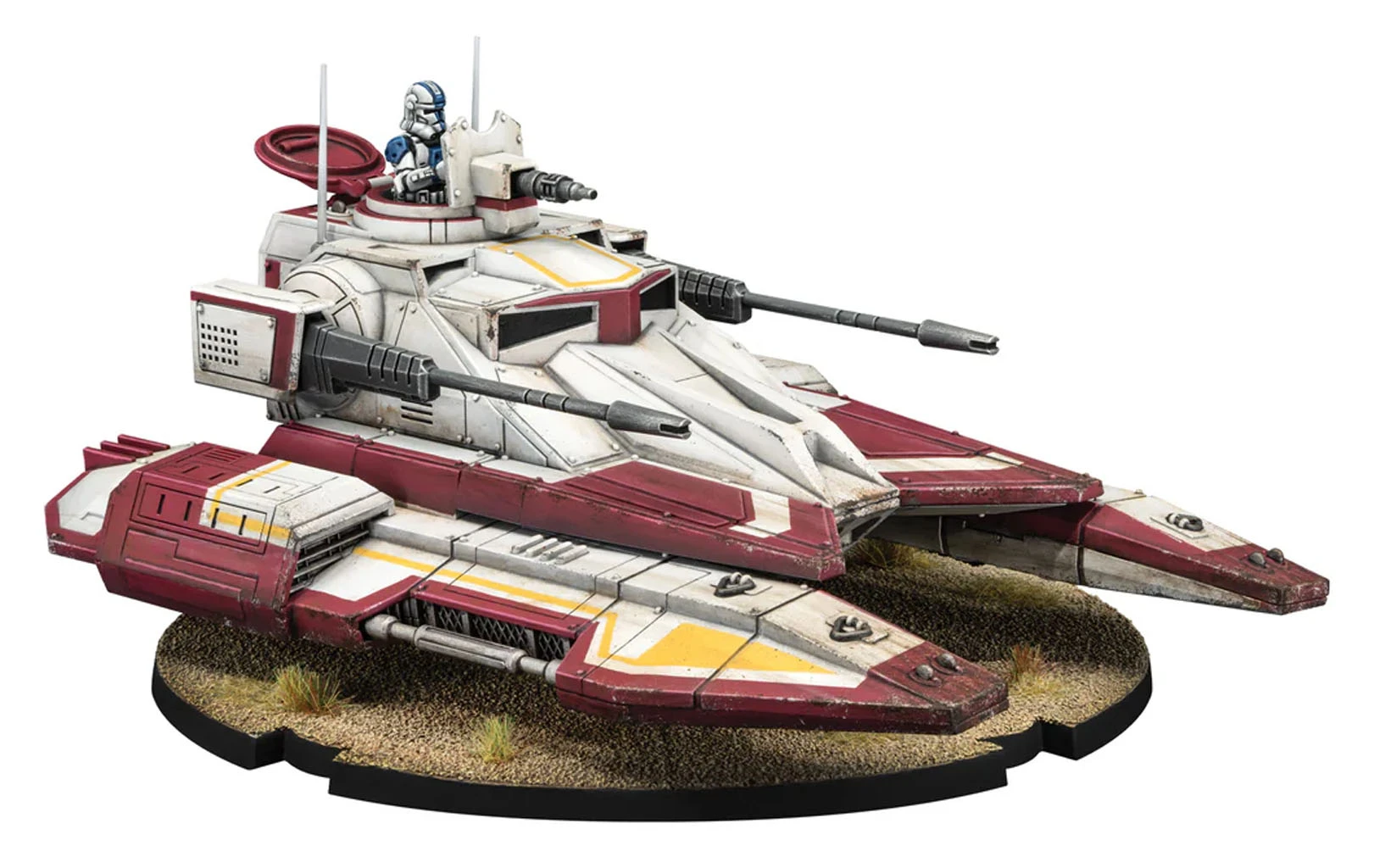 A detailed miniature of the TX-130 Saber-class fighter tank, featuring a sleek design with a predominantly white and red color scheme. The tank is equipped with a beam cannon and twin laser cannons, showcasing its heavy armament. A clone trooper pilot is seated in the turret, and the base is textured to resemble a sandy terrain with small patches of grass.