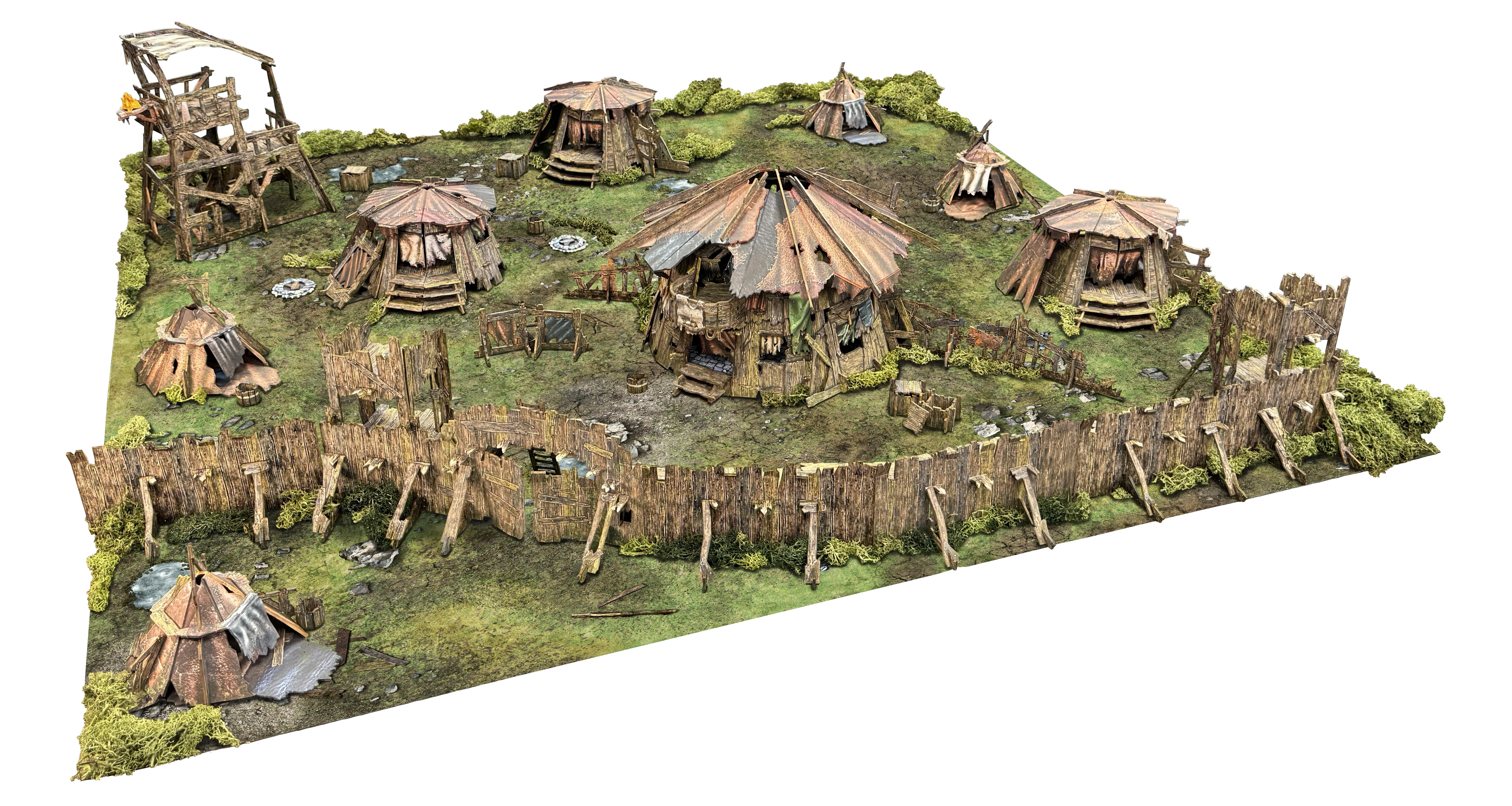 A detailed tabletop terrain scene depicting a primitive encampment, featuring several round huts with thatched roofs, surrounded by a makeshift wooden barricade. The terrain includes a large roundhouse, smaller huts, and various barrels, with patches of greenery and a dirt ground. The overall design reflects a rugged, barbarian aesthetic suitable for fantasy gaming.