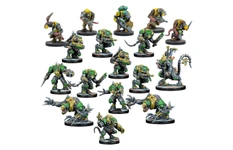 A diverse group of Verr-Myn miniatures is displayed, showcasing various characters from the faction. Prominent figures include heavily armored Stalkers and Runners wielding weapons, alongside smaller Thralls and a formidable Crone Mother with bio-augmented features. The miniatures feature a mix of green and gray colors, with intricate details highlighting their cybernetic enhancements and weaponry, all set against a plain white background.