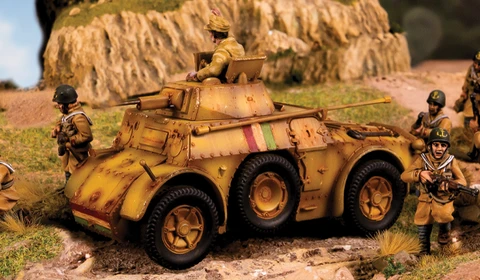 An Italian Autoblinda AB41/43 Armoured Car is prominently featured in the foreground, showcasing a weathered yellow and brown camouflage pattern. The vehicle has a turret with a soldier positioned on top, while several infantry soldiers in tan uniforms are scattered around it, engaged in various poses. The background includes rocky terrain and greenery, enhancing the military setting.