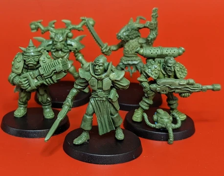 A group of five 28mm scale sci-fi miniatures is displayed against a bright red background. The figures include a Space Commando wielding a rifle, a Starchild with a distinctive helmet, an Assault Goar holding a sword, a Space Orc with a large gun, and a Voidborn equipped with various gadgets. Each miniature features intricate details and a classic old-school aesthetic, showcasing the unique character and charm of the RT Adventurer Pack II from Satyr Art Studios.