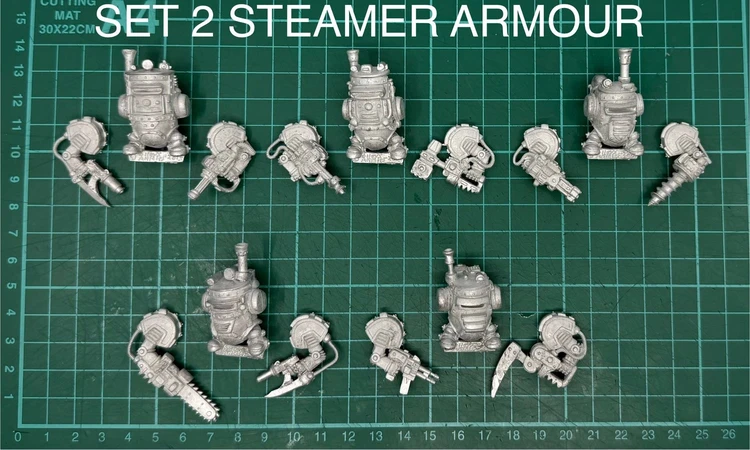 A collection of multipart, white metal miniatures featuring steampunk-style armoured dwarves, arranged on a green cutting mat. The set includes various dwarf figures in distinctive power armour, alongside an assortment of weapon arms, such as guns and mechanical claws. The text