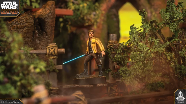A detailed miniature of Luke Skywalker stands on a rocky terrain, holding a blue lightsaber in one hand and a blaster in the other. He is dressed in a yellow jacket with black accents, and the background features lush greenery and wooden structures, creating a vibrant and dynamic scene. The image captures the essence of the Star Wars universe, highlighting the character's iconic look and the adventurous setting.