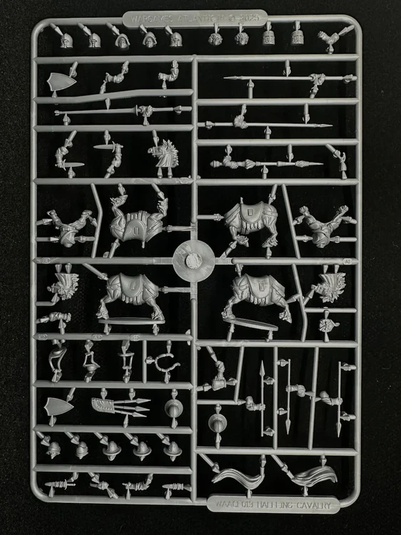 A sprue of plastic multipart miniatures featuring various components for halfling cavalry. The layout includes several halfling bodies, arms, and weapons, alongside stout pony figures. The pieces are intricately detailed, showcasing a variety of poses and accessories suitable for building a dynamic halfling army.