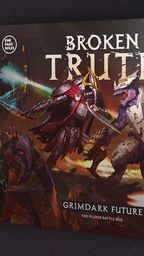 A box cover for "Grimdark Future: Broken Truth" features a dynamic illustration of two opposing factions: a menacing armored figure wielding a glowing weapon and a reptilian warrior in futuristic armor. The background showcases a chaotic battlefield with hints of advanced technology and dark, fiery colors. The title "BROKEN TRUTH" is prominently displayed at the top, with "GRIMDARK FUTURE" and "TWO PLAYER BATTLE BOX" at the bottom.