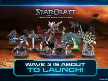 Six miniature figures on a tabletop: a purple Zerg creature with wings and claws, a Terran soldier with a gun, a green Zerg figure, a Terran ghost in white armor, a Protoss warrior with a sword, and a Protoss commander with a staff.