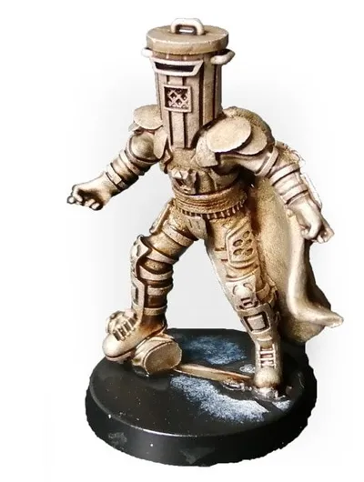 A gold-colored miniature figurine of a character wearing a cylindrical helmet resembling a trash bin, with a cape flowing behind. The figure stands on a round black base with a textured surface. The helmet has a handle on top and a small emblem on the front. The figure is posed with one arm extended forward and one leg slightly bent, as if mid-step.