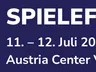 A promotional graphic for Spielefest Wien features bold white text on a deep blue background. The event name "SPIELEFEST WIEN" is prominently displayed at the top, followed by the dates "11. – 12. Juli 2026" and the location "Austria Center Vienna." The design includes dynamic lines on the right side, adding a modern touch to the overall layout.