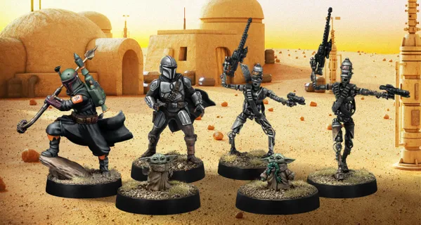 A group of four miniatures from the Star Wars universe is displayed against a desert backdrop featuring a simple structure. On the left, a character in a silver and black armor, resembling a bounty hunter, stands confidently. Next to him, two IG-Series Assassin Droids are posed with weapons drawn, showcasing their metallic bodies and intricate details. In the foreground, Grogu, a small figure with large ears, is depicted holding a small object, adding a whimsical touch to the scene. The ground is textured with grass and dirt, enhancing the overall aesthetic of the miniatures.