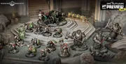 Miniature figures of armored duardin warriors in green and silver plate, standing on a rocky battlefield. One figure holds a large green banner with a white circular emblem. A cannon with a crew of two figures is positioned on a raised platform.
