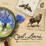 A magnifying glass over a blue flower, a moth illustration labeled "Alucita hexadactyla", a goat-like animal sketch, and a parchment with handwritten text. Title reads "Carl vr. Linné" with credits: "Michal Peichl, Michal Řezníček, Stanislava Pajonkova". Pink Troubadour logo in top-right corner.