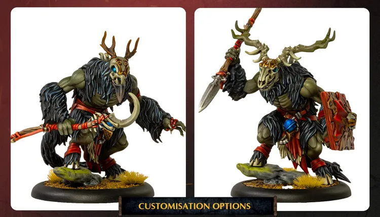 Two detailed miniatures are displayed side by side, showcasing customization options for characters in the Old Umbrey Command Starter and Battlegroup Box. On the left, a creature with a skeletal mask and antlers wears a tattered cloak, holding a curved blade and adorned with tribal accessories. On the right, another figure features a similar skeletal motif, wielding a spear and displaying a more muscular build, with vibrant colors and intricate details in their attire. Both figures stand on textured bases with tufts of grass, emphasizing their connection to the natural and mystical elements of the game.