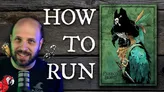Man with short hair and beard, smiling, wearing a dark shirt with a red parrot graphic. Microphone in front of him. Text overlay reads: "HOW TO RUN". Two small parrot illustrations flank the text. Wooden wall background.