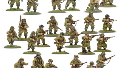 A collection of multi-part plastic miniatures representing US Airborne soldiers in early war, reinforced M42 jump uniforms. The figures are posed in various action stances, showcasing a range of weapons including rifles, submachine guns, and a bazooka, along with additional gear like magazine pouches and a signal lamp. The miniatures are set on grassy bases, highlighting their detailed sculpting and variety within the thirty-man platoon.