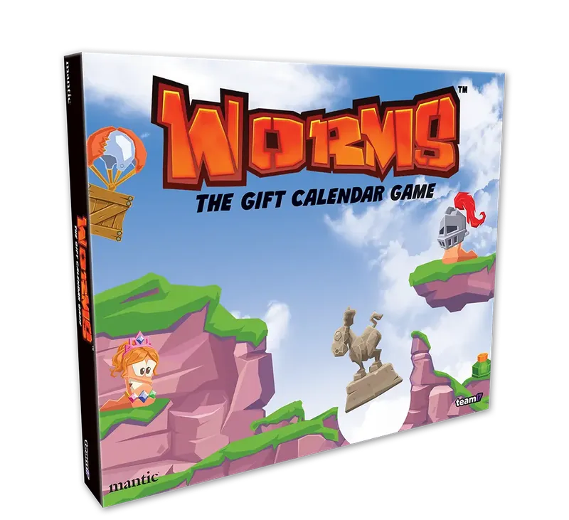 A colorful box for "Worms: The Gift Calendar Game" features a vibrant illustration of cartoonish landscapes with green hills and rocky cliffs. Prominent characters include a pink worm wearing a crown and a knight, both positioned on the cliffs, while a hot air balloon floats in the sky. The title is boldly displayed at the top, emphasizing the festive theme of the advent calendar.