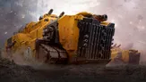 A large, heavily armored vehicle dominates the foreground, painted in a striking yellow with black accents. The vehicle features multiple gun barrels protruding from the top and a rugged, industrial design, emphasizing its role in combat. In the background, additional similar vehicles are partially visible, set against a smoky, war-torn landscape.