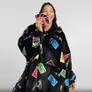 Woman in UNO card-patterned black hooded blanket holding UNO cards.