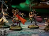 A trio of miniatures from the board game Warhammer Quest: Darkwater is displayed on a detailed game board. On the left, a character in a flowing red cloak wields a staff, while in the center, a heavily armored warrior brandishes a sword and shield, showcasing intricate details on their armor. To the right, a duardin ranger holds an axe and has a backpack filled with adventuring gear, all set against a richly colored background that enhances the fantasy theme.