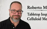 Man with glasses and beard, text: "Roberto M Tabletop In Celluloid M"