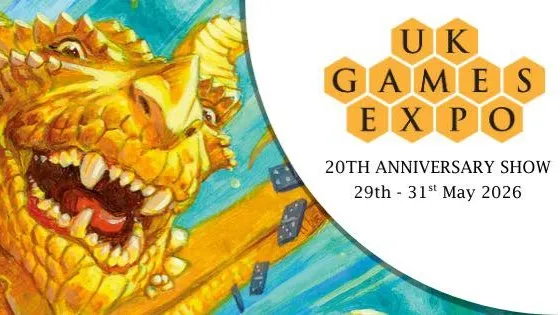 A vibrant illustration features a large, golden dragon with a playful expression, showcasing its sharp teeth and prominent features. The dragon is surrounded by a blue background with scattered game dice, emphasizing a whimsical and dynamic atmosphere. The UK Games Expo logo is prominently displayed in the corner, indicating the event's 20th anniversary from May 29th to 31st, 2026.