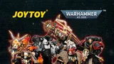 A dark background with a group of seven detailed action figures in the center, each wearing ornate armor with skull motifs, capes, and weapons. The figures are arranged in a dynamic pose. At the top, the text "JOYTOY" in yellow and "WARHAMMER 40,000" in white with a blue and silver logo. Below the figures, the text "REINFORCEMENTS IMMINENT!" in large white letters, followed by "BLACK TEMPLARS, RAVEN GUARD, BLACK LEGION & SPACE WOLVES" in smaller white text.