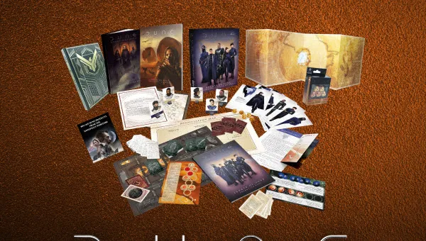 A collection of items from the Dune RPG Physical Megabundle is displayed against a textured brown background. The assortment includes various books, game components, and promotional materials, prominently featuring the Dune logo and the text "Supporting: ACLU." The items are arranged in a visually appealing manner, showcasing the core rulebook, adventure modules, and other game accessories.