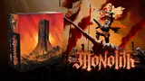 Armored figure on a skull, holding a flag with text "The Monolith" below.