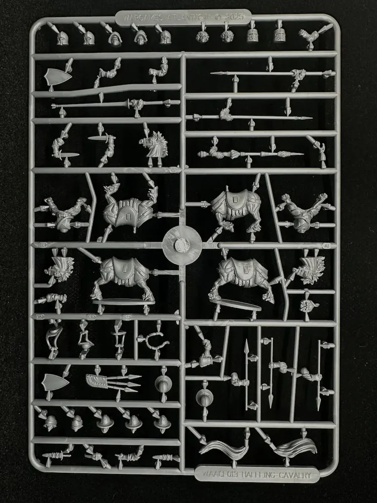 A sprue of plastic multipart miniatures featuring various components for halfling cavalry. The layout includes several halfling bodies, arms, and weapons, alongside stout pony figures. The pieces are intricately detailed, showcasing a variety of poses and accessories suitable for building a dynamic halfling army.