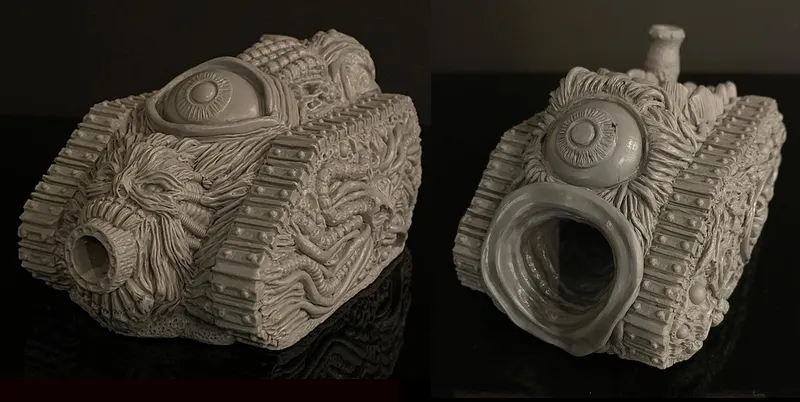 A grotesque tank model designed for a Chaos army, featuring a textured surface adorned with various orifices, boils, and an eye-like detail on the front. The tank has a large, gaping mouth-like opening, emphasizing its disturbing aesthetic. The model is presented in a gray, unpainted finish, showcasing intricate sculpting details that highlight its bizarre and unsettling design.