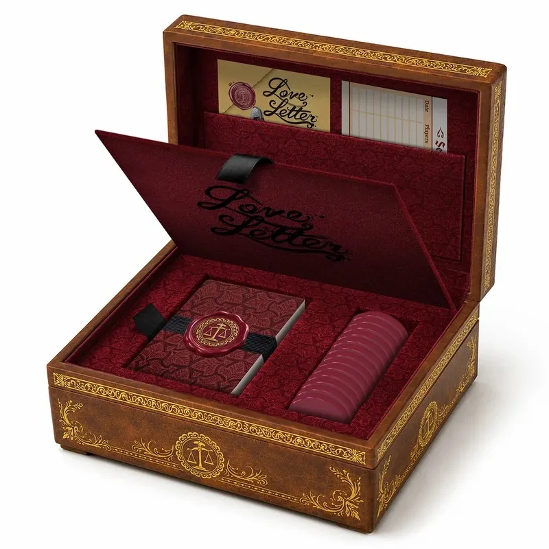 Open wooden box with red interior, Love Letter game components, and gold embossed lid.