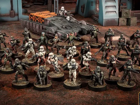 Miniature soldiers in armor and a gray tank on a muddy battlefield.