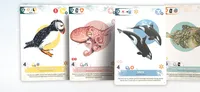 Three game cards displayed side by side. Left card shows a polar bear with text "Polar Bear" and gear icons. Center card features a labeled diagram of a North Atlantic octopus with text "North Atlantic Octopus, Bathyplpus arcticus" and a description about its metabolism.