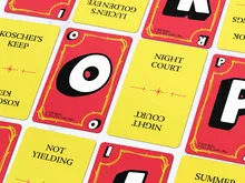 Five game cards with large black letters on red and yellow backgrounds. Visible text: "KOSCHEI'S KEEP," "NIGHT COURT," "LUCIN'S GOLDEN EYE," "SUMMER COURT," "NOT YIELDING," and "PRIORITIES" logo with small stars. ©2015-2026, Sarah J. Maas.